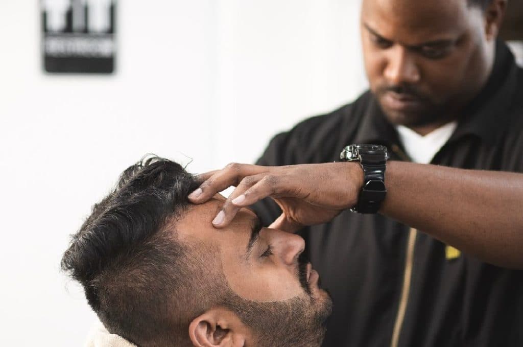 Johnnie J working with a client in the barbershop